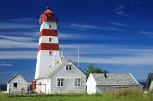 Roter und weißer Leuchtturm von Alnes unter blauem Himmel