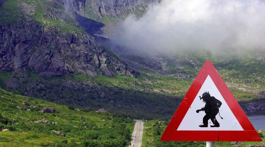 Sign warning for crossing Trolls in a green valley between Ålesund and Åndalsnes, Norway