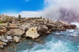 Cairns, stones and rocks on the waterside at the top of the Stigfossen waterfall and the Troll Road in Norway