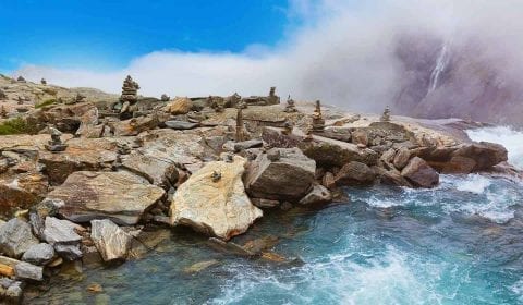 Steenmannetjes, stenen en rotsblokken langs de waterkant aan de top van de Stigfossen waterval en de Troll Road in Noorwegen