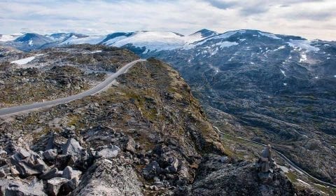 Utsikt fra Dalsnibba over fjellene med litt snø og fjellveien