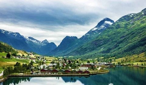 View over the rural village of Olden, situated in a green valley, surrounded by impressive mountains