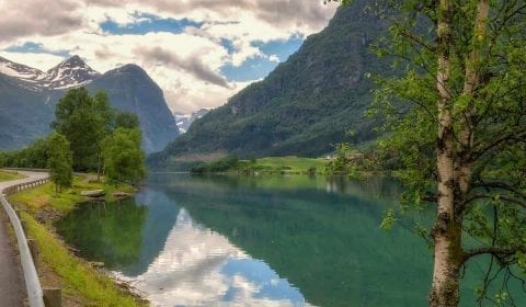 Idyllisch meer tussen de hoge bergen onderweg van Olden naar Geiranger