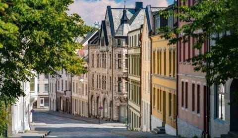 Rustige straat met groene bomen en kleurrijke Art Nouveau huizen in het centrum van Ålesund, Noorwegen