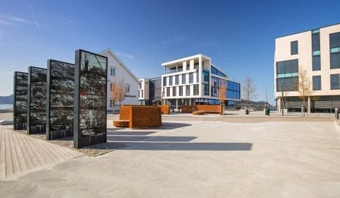 Denkmal für den Stadtbrand in Ålesund auf Skansekaia, moderne Bürogebäude im Hintergrund