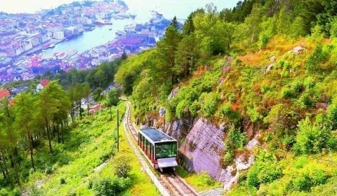 View of the floyen funicular going uphill in Bergen, the city center in the background