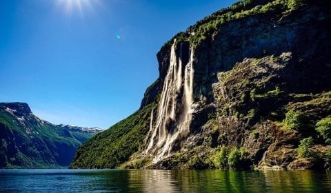 De syv søstre fossen under en klarblå himmel, solen skinner i Geiranger, Norge