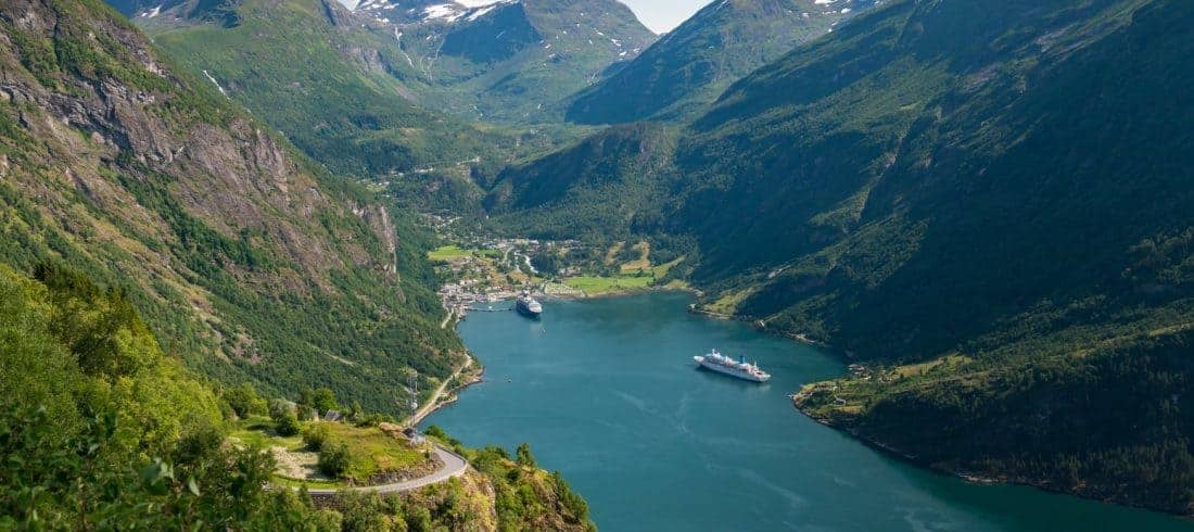 High green mountains surrounding the Geirangerfjord where two ships are in port, view from the Eagle Road