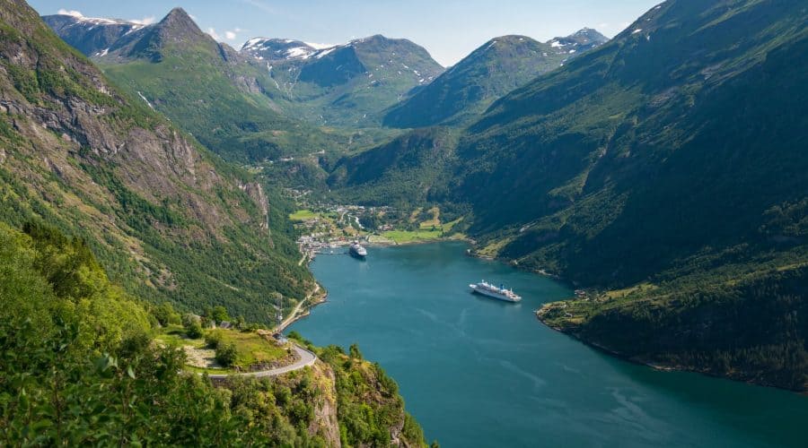 High green mountains surrounding the Geirangerfjord where two ships are in port, view from the Eagle Road