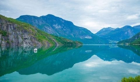 Turquoise coloured lake of Oppstrynsvatnet between Hellesylt and Geiranger, surrounded by mountains, Norway