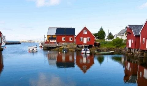 Rode en witte houten huizen in het dorp Bud onderweg naar de Atlantic Ocean Road in Noorwegen