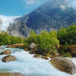 The Briksdal glacier, arm of the Jostedal Glacier, hanging from a mountain, fresh water passing in a stream, Olden, Norway