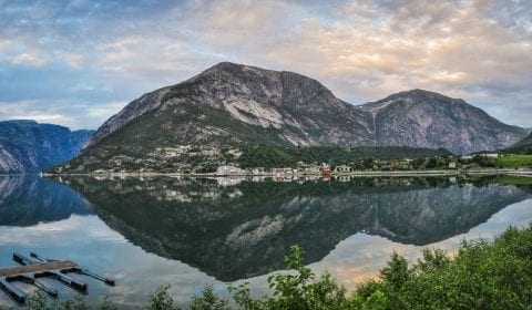 Pietre nell'acqua limpida del fiordo vicino a Eidfjord sotto un cielo azzurro