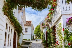 Wooden houses and cobblestone streets of Gamle, Stavanger with flowers in bloom