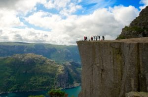 A view of people standing on top of Pulpit Rock (Priekestolen) above the Lysefjord
