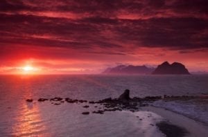 A pink glow from the midnight sun over the ocean in Norway.