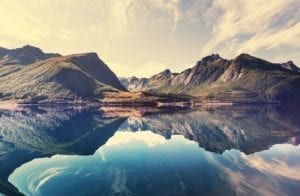 A view of a mountain range in the background with a beautiful lake reflecting the mountains in the foreground, Norway.