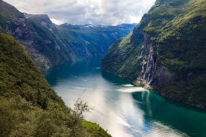 a view looking over the Geirangerfjord and the Seven Sisters waterfall across the fjord