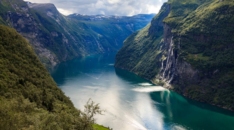 a view looking over the Geirangerfjord and the Seven Sisters waterfall across the fjord