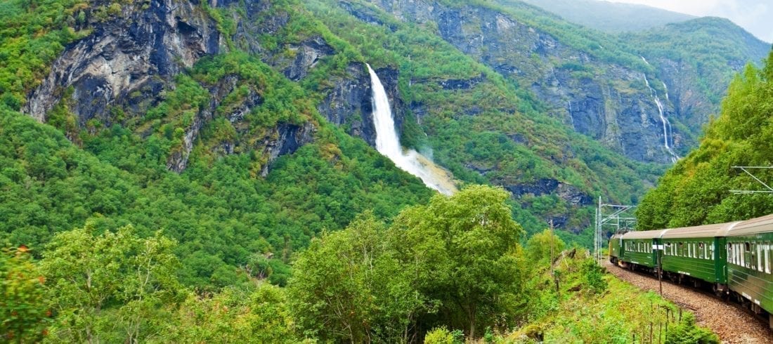 A train journeying through a beautiful Norwegian landscape.