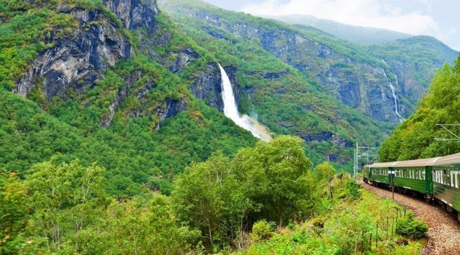 A train journeying through a beautiful Norwegian landscape.