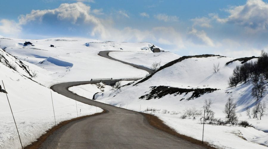 a windy road through a snowy landscape to get to a cabin, Norway.