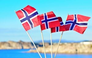 Norwegian flags flying in front of a beautiful Norwegian landscape.