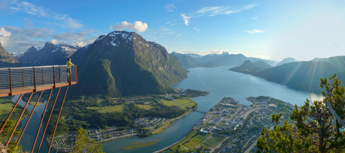 A view of Rampestreken viewing platform and the Romsdal valley, mountains, and fjord below.