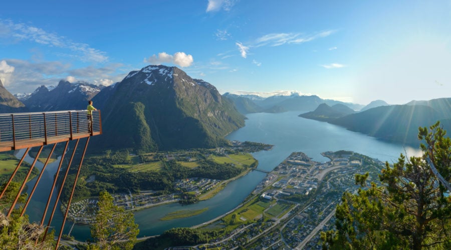 A view of Rampestreken viewing platform and the Romsdal valley, mountains, and fjord below.