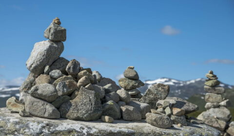 Pila equilibrada de piedras en Eidfjord, Noruega. Con nieve y montañas como fondo.