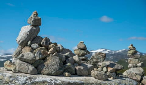 Balanced stack of stones at Eidfjord, Norway. With snow and mountains as background.